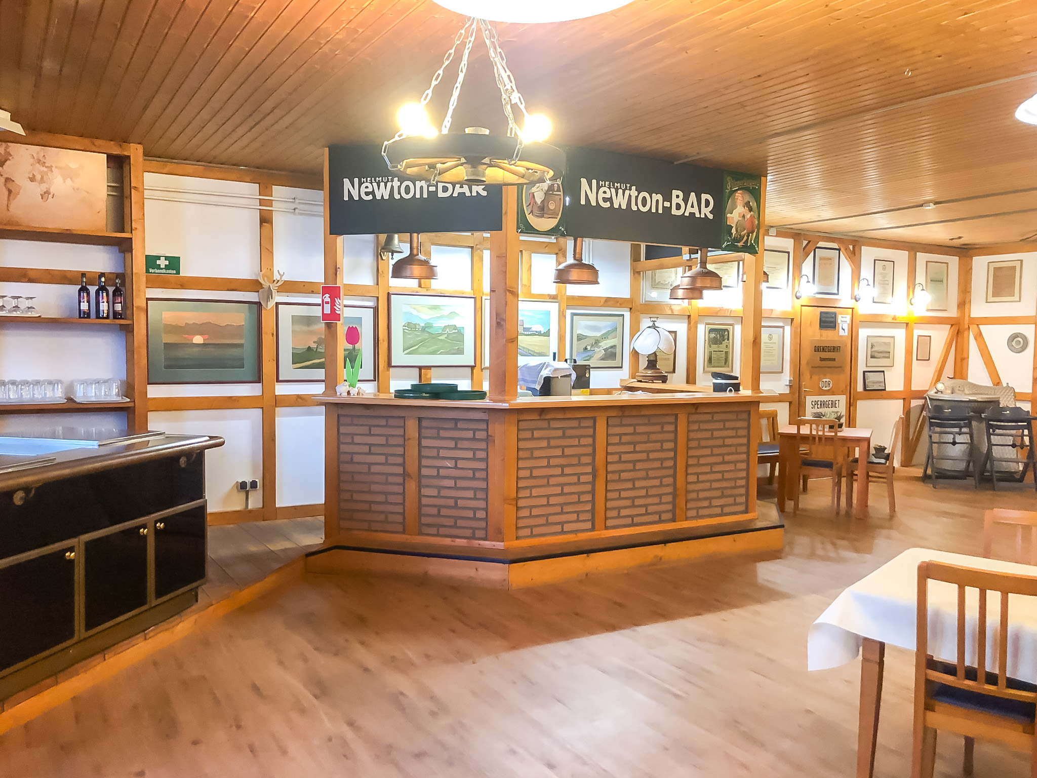 Einladender Barbereich mit Holzverkleidung und stimmungsvollem Licht – ideal für Empfänge, Feiern und gesellige Runden.