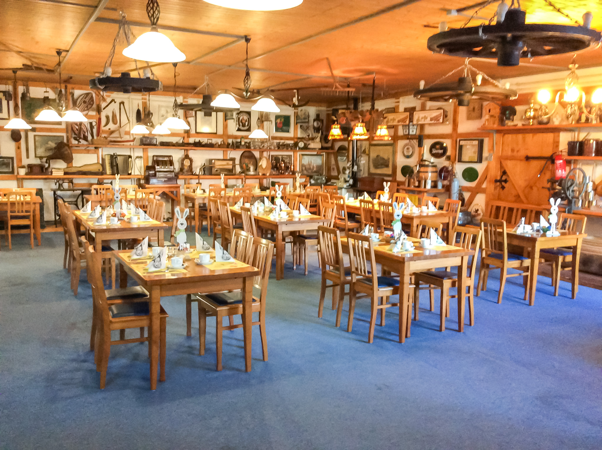Gemütlich dekorierter Veranstaltungsraum mit Holzdecken, heller Beleuchtung und stimmungsvoller Einrichtung für Familienfeiern oder Brunch.